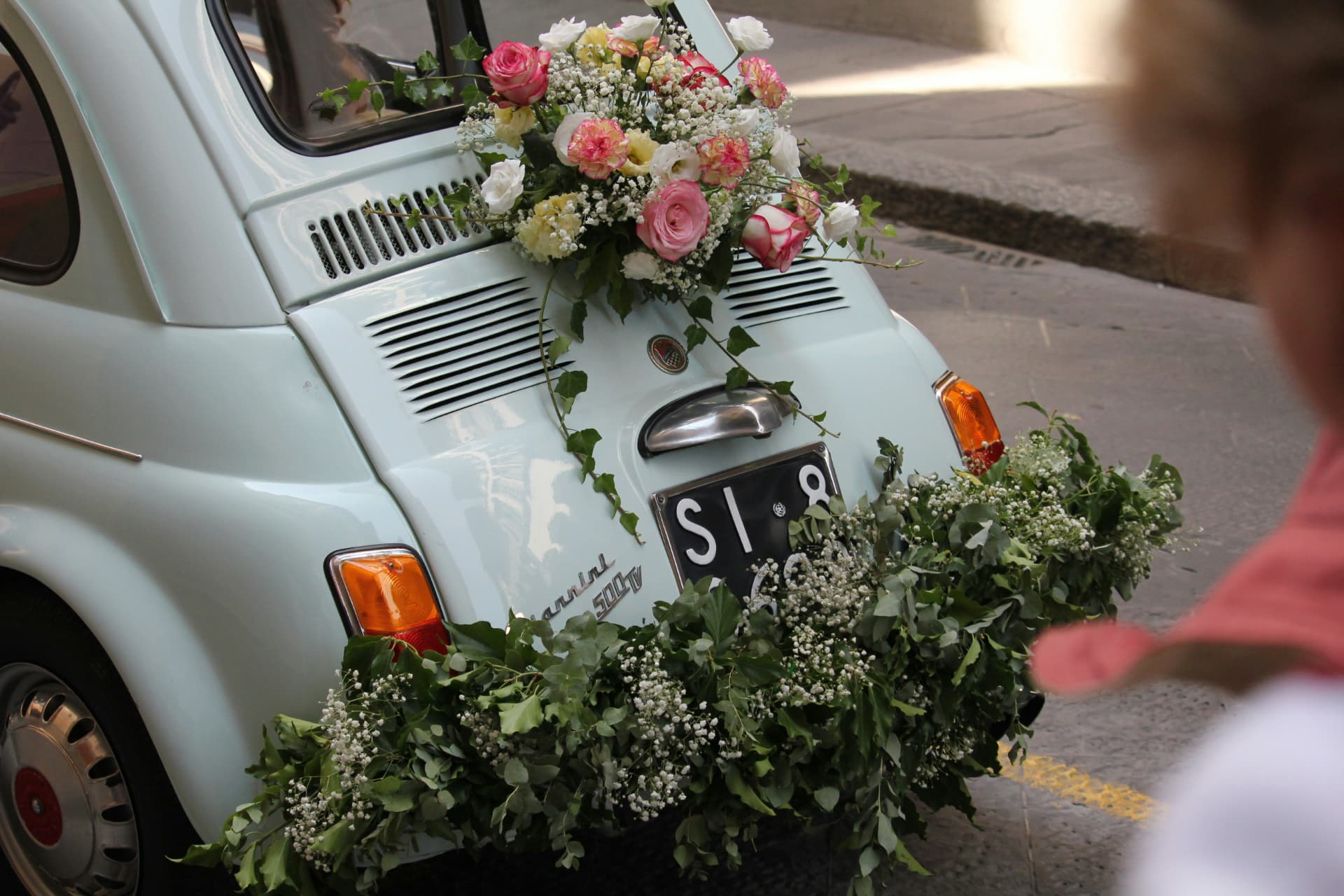 Vintage getaway car dressed in roses and trailing greenery